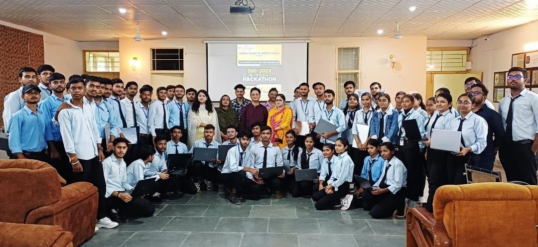 Students holding laptops with faculty at the SIH-2025 Internal Hackathon in the VCM seminar hall